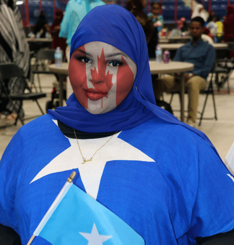 Somali girl wearing Somali flag clothing with Canadian flag painted on her face